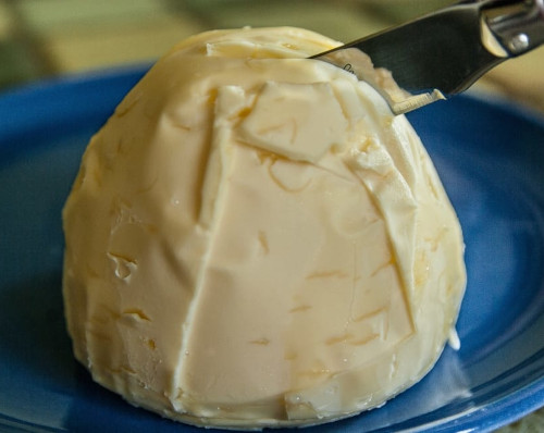 The image shows the lump of butter with a knife stuck in it.