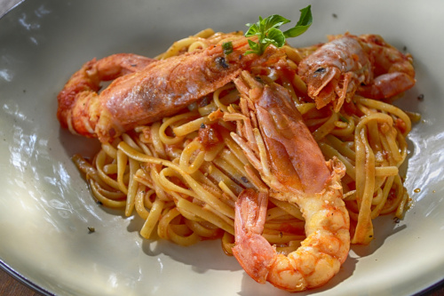 A bowl of spicy cajun shrimp pasta with big shrimps