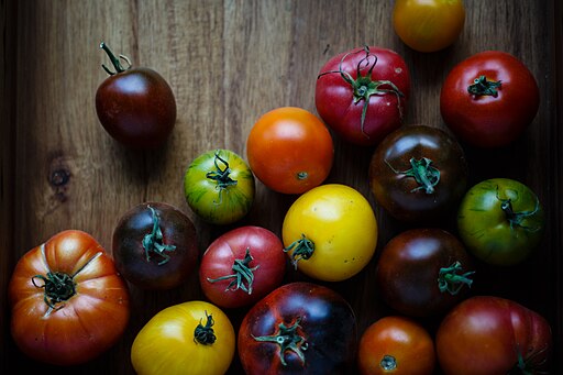 The image shows diverse colors of Heirloom Tomatoes