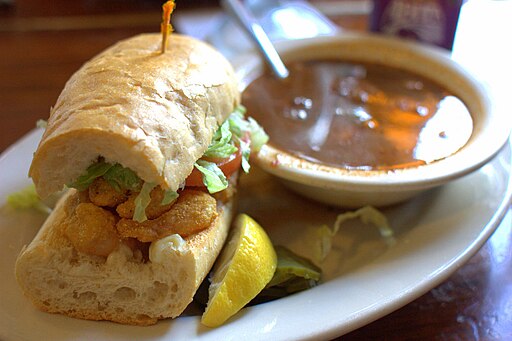 The picture exhibits Shrimp Po'Boy in the white dish on the table