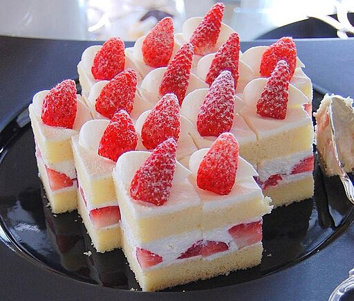 The image shows several strawberry shortcakes on the black dish