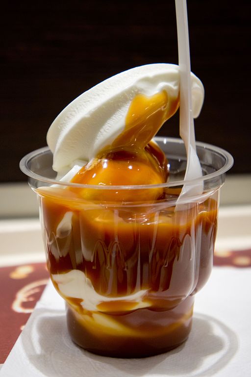 The image shows ice cream in a plastic cup decorated with salted caramel.
