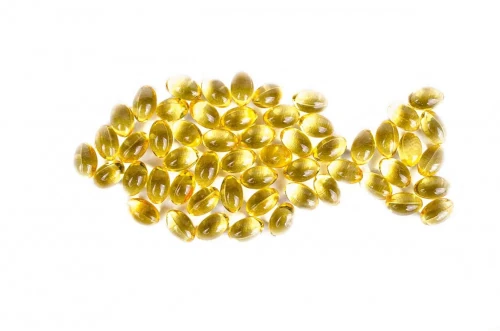 A picture depicting Omega-3 capsules arranged in the shape of fish.