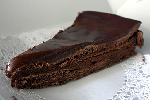 The image shows chocolate cake on the paper dish